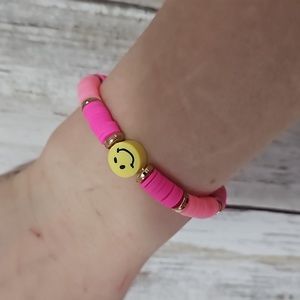 Clay bead bracelet with pink beans and a yellow smiley face